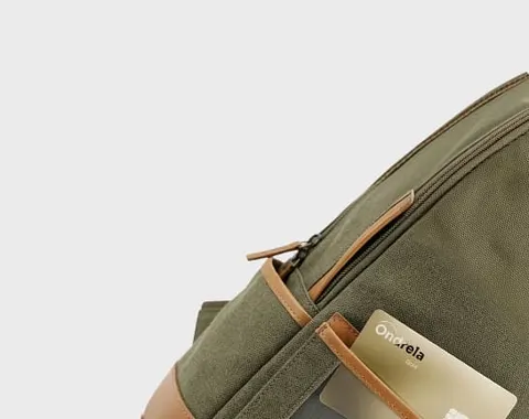 Cart&atilde;o localizador dourado enfiado na bolsa de uma mochila em viagem
